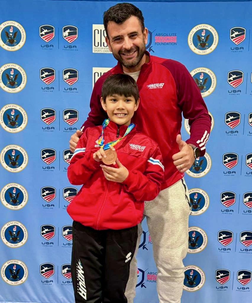 Young Nova fencer with his medal alongside his coach